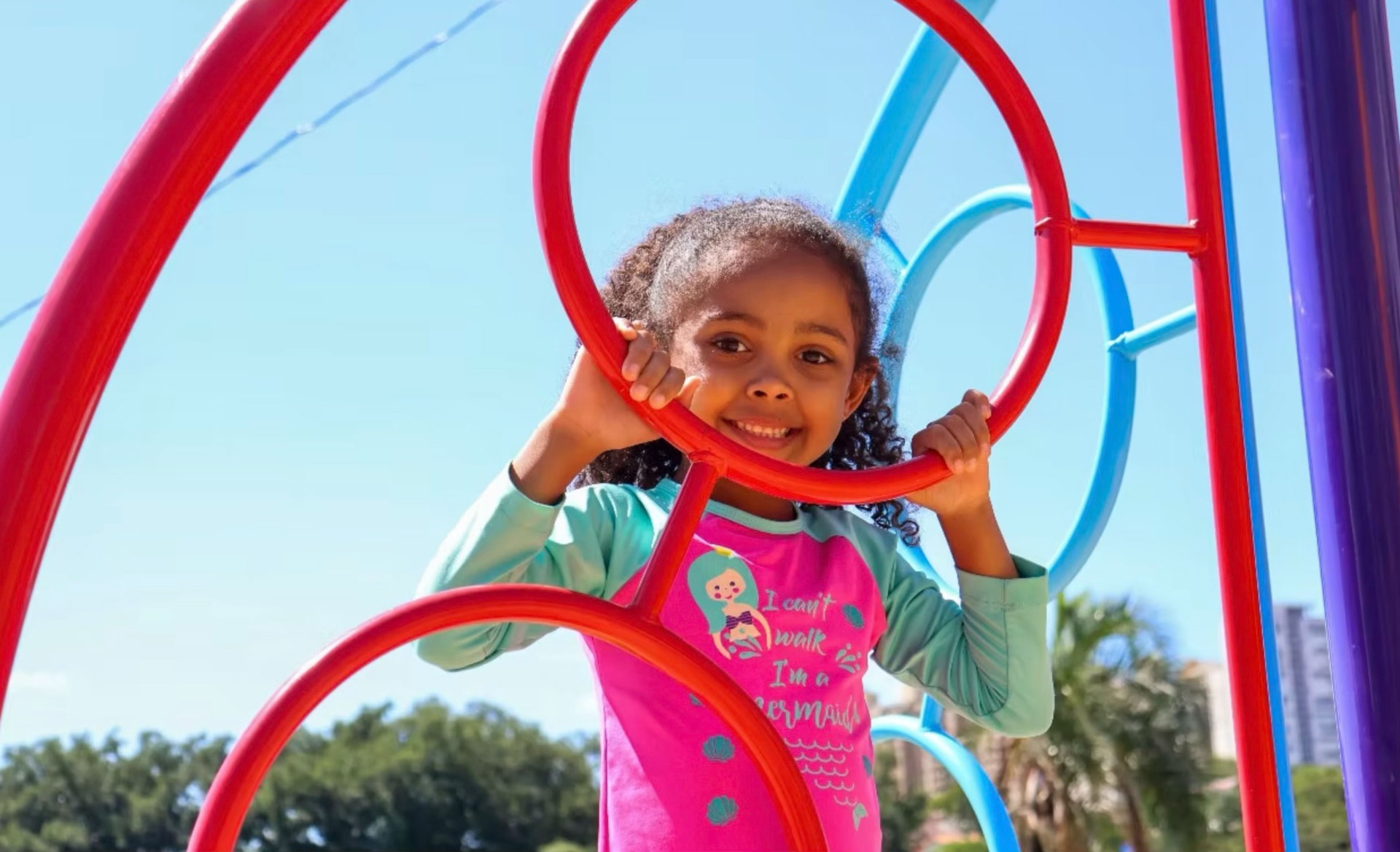 Menina sorridente brincando no playground do CPTI